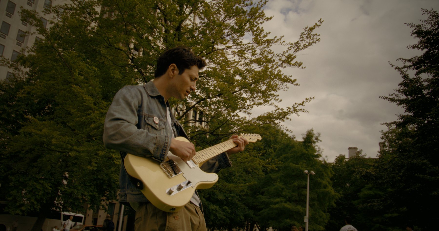 Huebline playing guitar on set